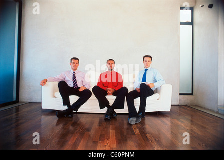 Hommes d'sitting on couch in office Banque D'Images