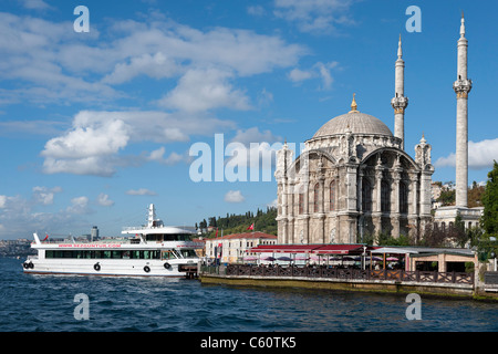 Mosquée Ortakôy ( également connu sous le nom de mosquée Mecidiye) et un bateau d'excursion sur la rive du Bosphore à Istanbul Banque D'Images