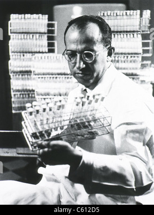 Jonas E. Salk (1914-1995), American medical chercheur qui a mis au point le premier vaccin contre la polio, holding tray de tubes à essai. Ca. 1955. Banque D'Images