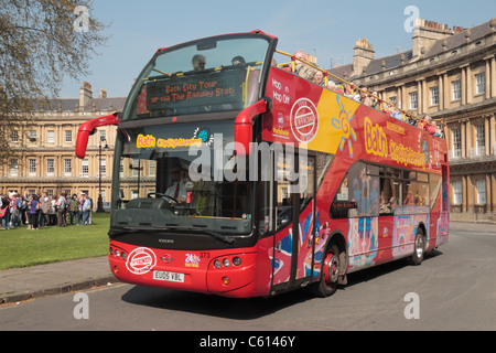 Une baignoire bus touristiques des environs de la conduite des propriétés sur le Circus à Bath, Somerset, Angleterre. Banque D'Images