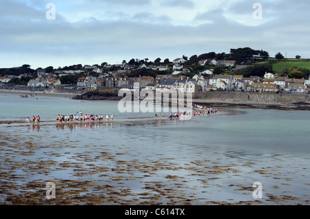 Les personnes qui traversent la mer à marée basse à marazion de St Michael's Mount. Banque D'Images