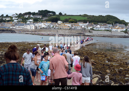 Les personnes qui traversent la mer à marée basse à marazion de St Michael's Mount. Banque D'Images