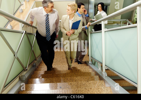 Image de gens d'affaires de monter à l'étage et de communiquer dans l'immeuble de bureaux Banque D'Images