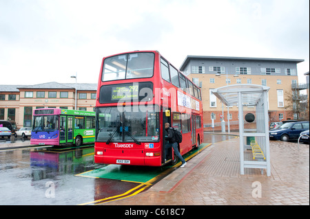 L'embarquement des passagers d'un bus à impériale rouge dans Transdev livery attendant à un arrêt de bus. Banque D'Images