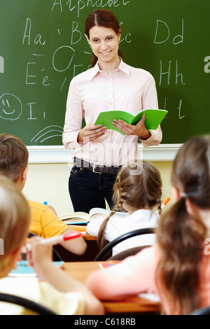 Portrait d'enseignant avec smart livre d'exercice à la salle de classe à schoolkids dans Banque D'Images