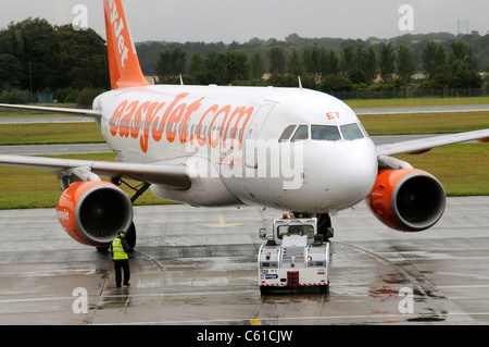 L'appui au sol service à l'aide d'un tracteur pushback pour déplacer un Airbus d'Easyjet sur la voie de circulation à l'aéroport d'Edinburgh Scotland UK Banque D'Images