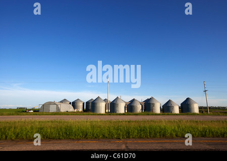 Cours de conduite les silos à grains sur les terres agricoles ouvertes du Dakota du Nord, USA Banque D'Images