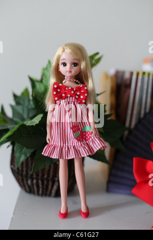 Poupée Barbie blonde en robe rose avec une gorge rouge Banque D'Images