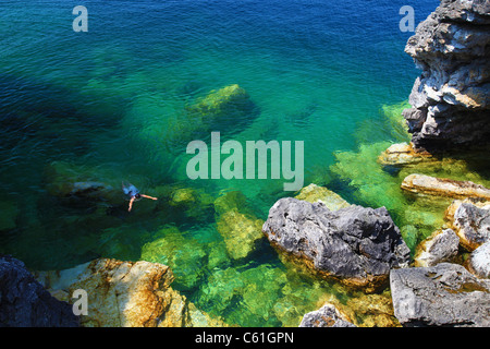 Un homme nager dans l'eau cristalline à Tobermory, près de la rive de la baie Georgienne, Ontario, Canada Banque D'Images