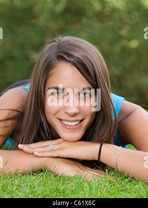 Cute young woman lying on grass in the park Banque D'Images