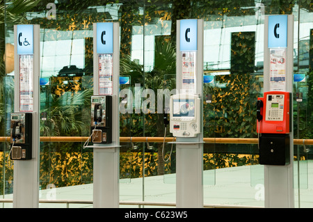 Téléphones publics dans le hall de départ côté ville, l'aéroport Changi de Singapour, de l'Aérogare 3 Banque D'Images