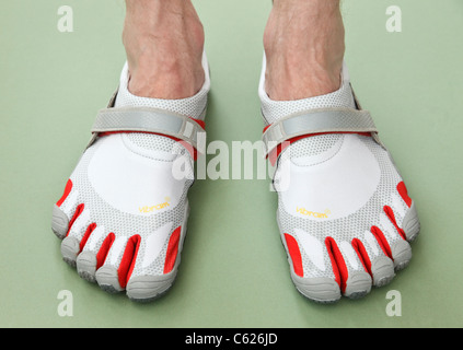 Un homme portant une paire de Vibram FiveFingers Bikila pieds nus athlétiques minimaliste pour la marche et la course, chaussures de sport. Banque D'Images