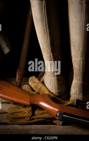 Boots et la carabine de peu de lumière la remise de jardin Banque D'Images