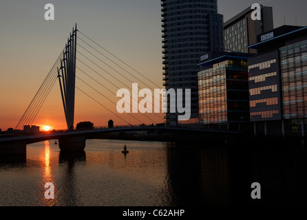 La passerelle au-dessus de la Manchester Ship Canal au coucher du soleil, menant à la BBC, la nouvelle maison à Media City, Salford Quays, Manchester Banque D'Images