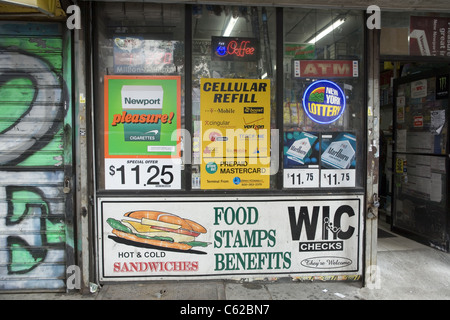 Petit magasin type bodega dans un quartier ouvrier et pauvre de Brooklyn annonce les bons alimentaires ainsi que des cigarettes et loto. Banque D'Images