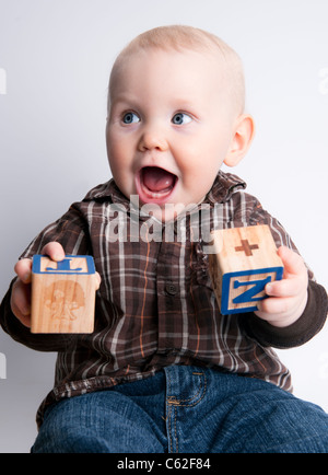 Bébé Garçon 9 mois, sourire, rire, jouer avec les blocs d'apprentissage. Banque D'Images