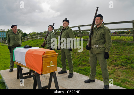 Des hommes vêtus d'uniformes paramilitaires de l'IRA avec un cercueil drapé dans un drapeau tricolore irlandais Banque D'Images