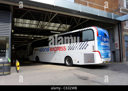 NATIONAL EXPRESS COACH, reconnaissable la livrée de la service de bus à l'échelle nationale, un entraîneur retourne à la gare routière de Victoria. Banque D'Images