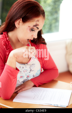 Femme remplissant formulaire de réclamation de dommage Banque D'Images