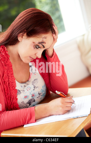 Femme remplissant formulaire de réclamation de dommage Banque D'Images