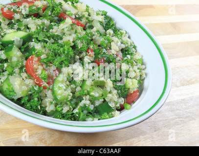 Taboulé de quinoa salade dans un bol, assis sur une table en bois. Banque D'Images