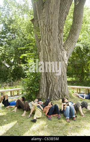 Les bénévoles se reposer sur une chaude journée d'été tout en travaillant à mettre dans un parc dans le quartier de Brightmoor ravagé Detroit, MI. Banque D'Images
