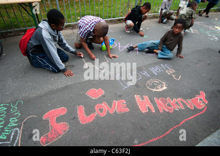 Clarence Road Hackney. Street tea party une semaine après les émeutes.Enfants dessinent à la craie sur le trottoir. Banque D'Images