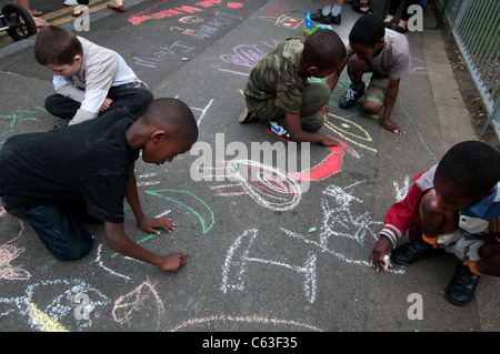 Clarence Road Hackney. Street tea party une semaine après les émeutes. Enfants dessinent à la craie sur le trottoir. Banque D'Images