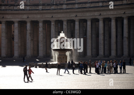 Visiteurs en face d'une fontaine sur la Place Saint Pierre à Rome, Italie, Europe Banque D'Images