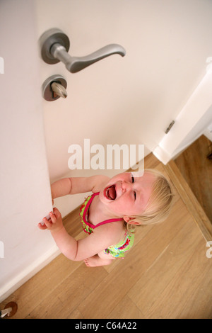 Avoir un enfant en colère à la maison porte avant. Banque D'Images