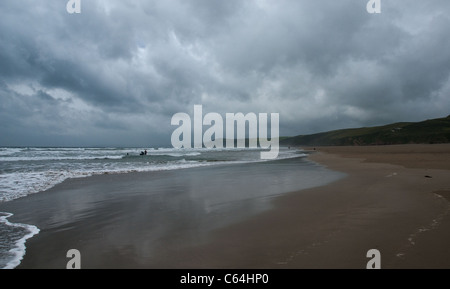 Cornwall, Whitsand Bay sur un jour venteux nuageux - des surfeurs dans l'arrière-plan. Banque D'Images