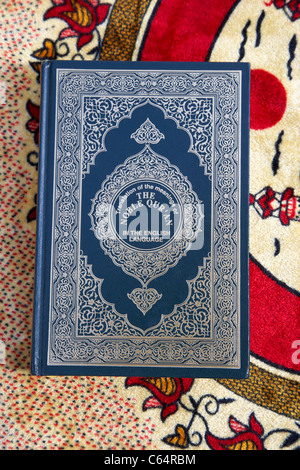 Noble Coran traduit version anglaise sur un tapis de prière musulmane Banque D'Images