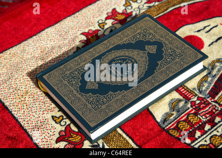 Noble Coran traduit version anglaise sur un tapis de prière musulmane Banque D'Images