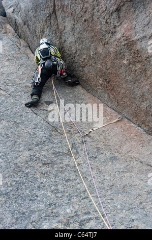 Un female rock climber climbing dans un style traditionnel à îles Lofoten, Norvège Banque D'Images