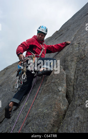 Un male rock climber climbing dans un style traditionnel à îles Lofoten, Norvège Banque D'Images