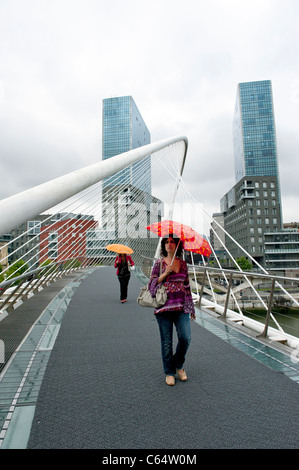 Des femmes portant un parapluie sur Santiago Calatrava Pont Zubizuri, Bilbao, dans le Pays Basque de l'Espagne Banque D'Images