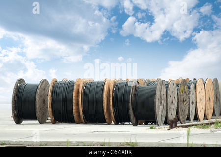 De gros rouleaux de câbles noirs sur fond de ciel bleu Banque D'Images