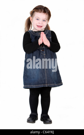 Joli bébé fille avec des mains en prière sur fond blanc Banque D'Images