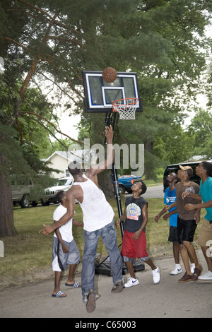 Les garçons jouent un jeu de basket-ball de rue dans le quartier de Brightmoor, Detroit, MI. Banque D'Images