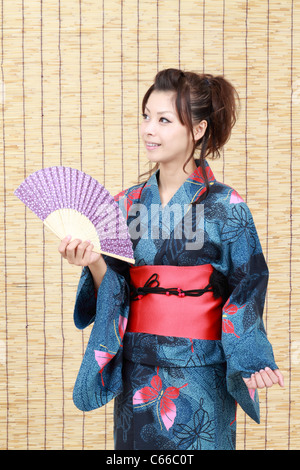 Jeune japonaise en vêtements traditionnels de kimono avec ventilateur papier japonais Banque D'Images