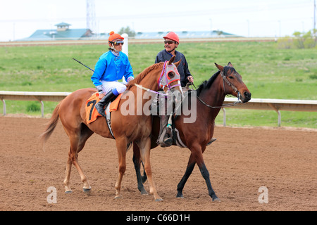 Aurora, CO - Jockeys préparer leurs chevaux pour les courses à Arapahoe Park Race Track Banque D'Images