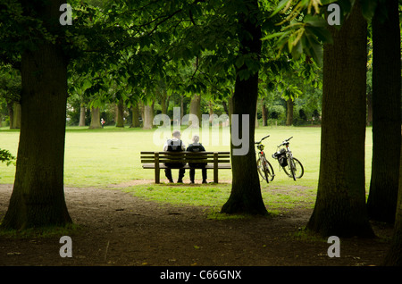 Couple d'agents de soutien communautaire assis sur un banc dans South Park, Oxford, Angleterre Banque D'Images