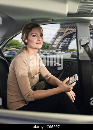 Woman using cell phone in car Banque D'Images