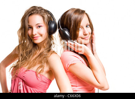 Radio de l'adolescence, deux magnifiques cute brunette teen girls having fun avec des écouteurs et de la musique, isolé sur fond blanc. Banque D'Images