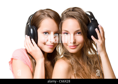 Radio de l'adolescence, deux magnifiques cute brunette teen girls having fun avec des écouteurs et de la musique, isolé sur fond blanc. Banque D'Images