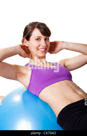 Belle jeune femme athlétique et faire des exercices sur un ballon de fitness Banque D'Images