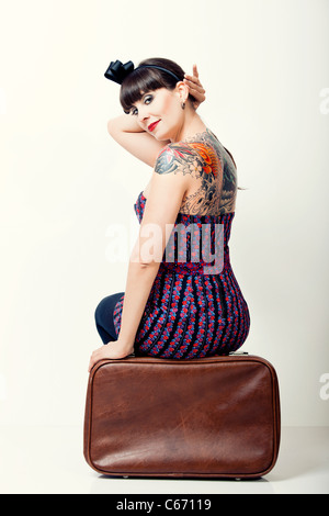 Portrait en gros plan d'une belle femme avec un style vintage assis sur un sac Banque D'Images