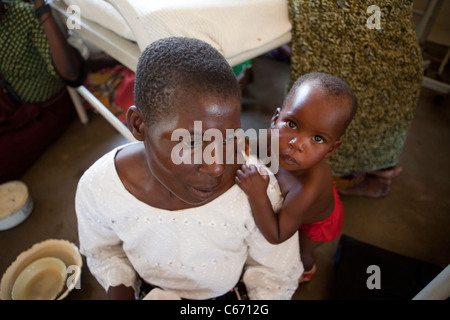 Une mère et son jeune enfant s'asseoir sur le sol d'un hôpital de Dedza, Malawi, Afrique du Sud. Banque D'Images