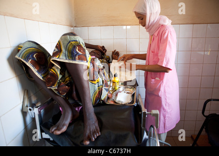Une femme reçoit un implant contraceptif dans le bras à une clinique de santé génésique à Bamako, Mali, Afrique de l'Ouest. Banque D'Images