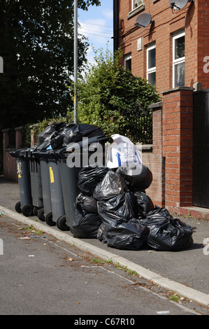 En retard pour plein wheelie bins collecte des déchets Banque D'Images